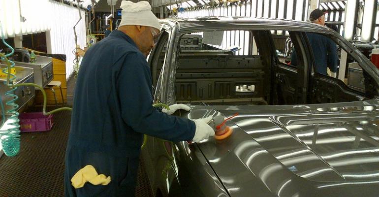 Plant worker inspects paint on F150 pickup 