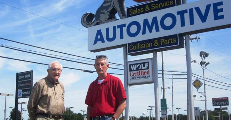 Jack Wolf left and nephew John Wolf stand in empty lot of defunct Wolf Chevrolet Jackrsquos store still open is across the street  